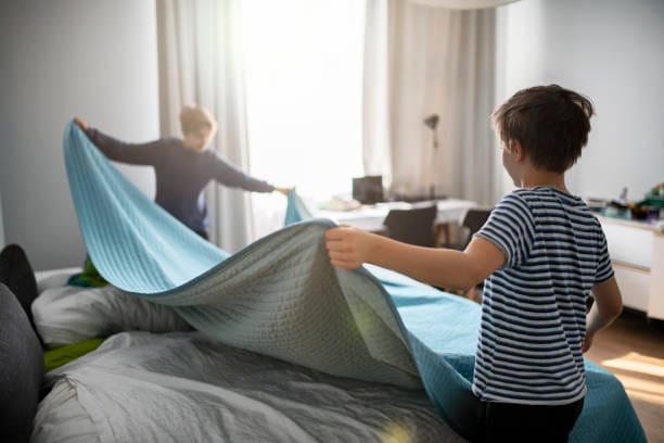 Two kids making bed, helping with housework.