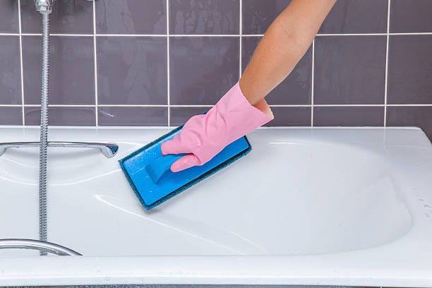 A cleaner demonstrating how to clean a bathtub